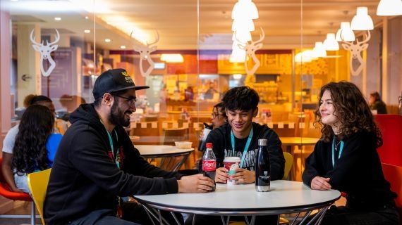 Three students sat round a circular table in Beats cafe