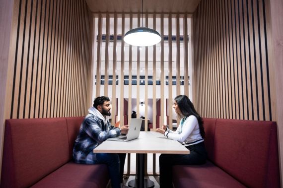 Students studying in a booth in the Atrium