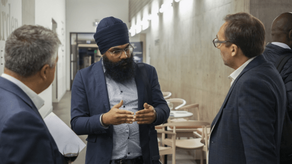Three BNU members of staff stood talking to one another.