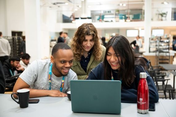 Students gathered together around a laptop