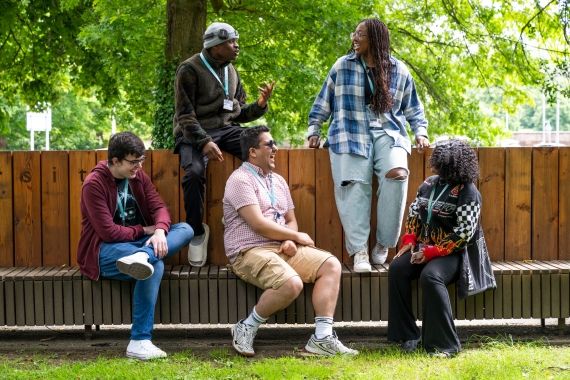 Five students sitting on a bench at High Wycombe campus