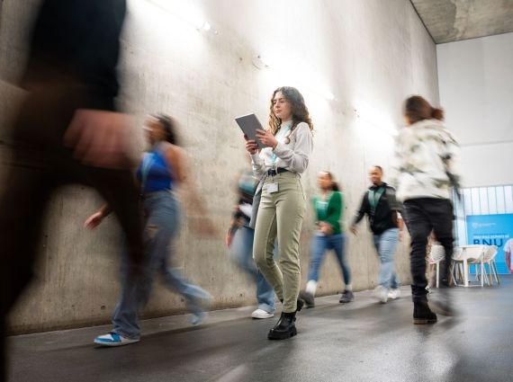 Students walking past concrete wall in gateway
