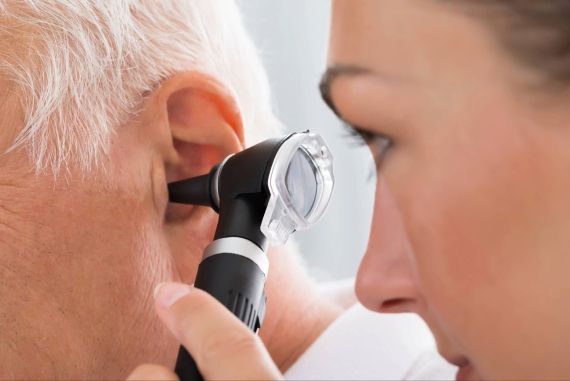 Female doctor examining patient’s ear with an otoscope
