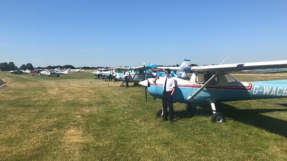 Planes lined up on an airfield on a sunny day
