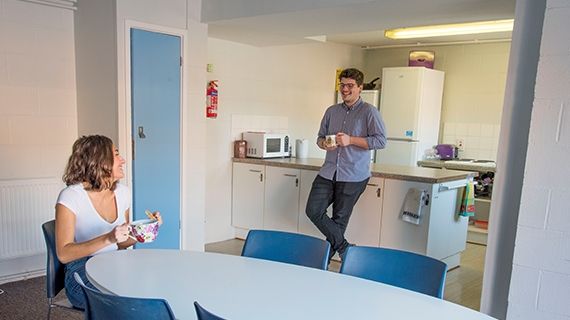 Two students in halls of residence holding mugs