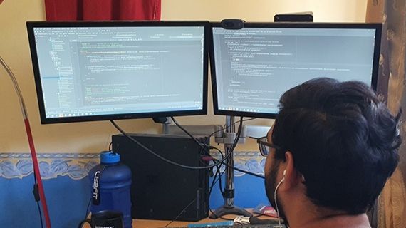 Neel sat looking at two computer screens