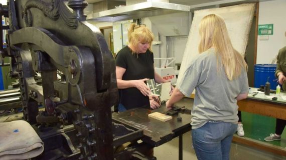 Two females using Printing press machine at BNU