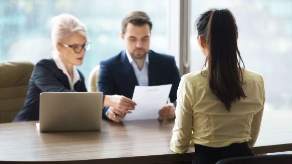 Young adult being interviewed by two people in a private office