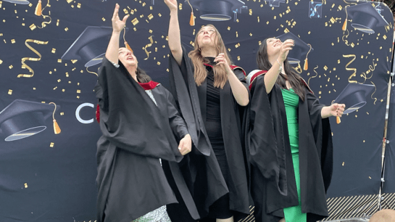Graduation Class of 2021 students throwing mortar board hats