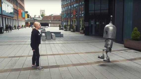 Female dance student dancing with human-size robot