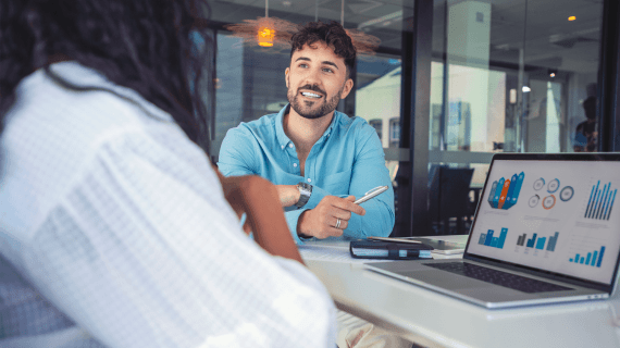 An accounting student in a meeting with another student whilst looking at data on a laptop