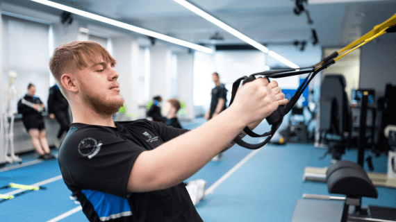 A Sports Therapy student pulling on resistance bands