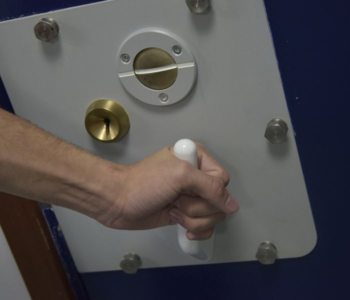 A police cell door handle being turned closed