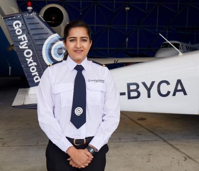 Female Aviation student standing in front of a plane