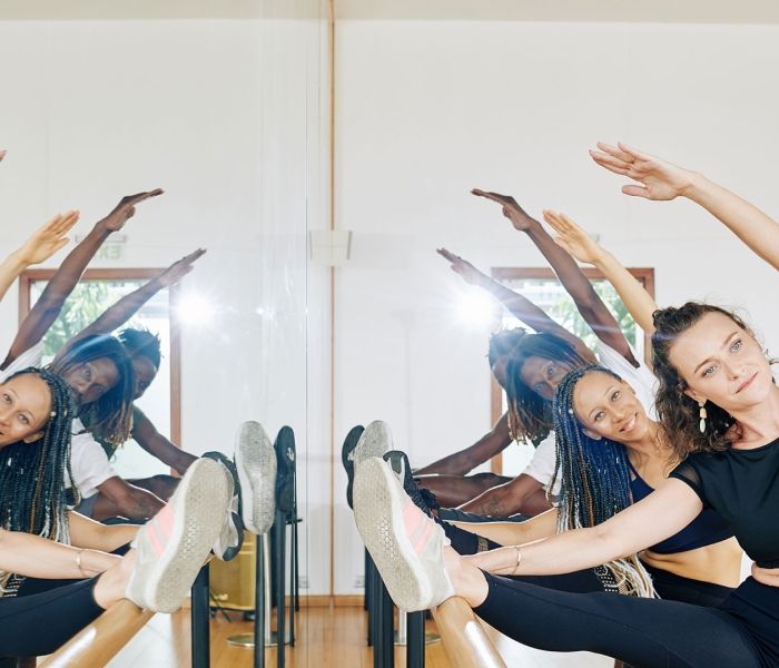 Two female and two male dancers stretching in studio