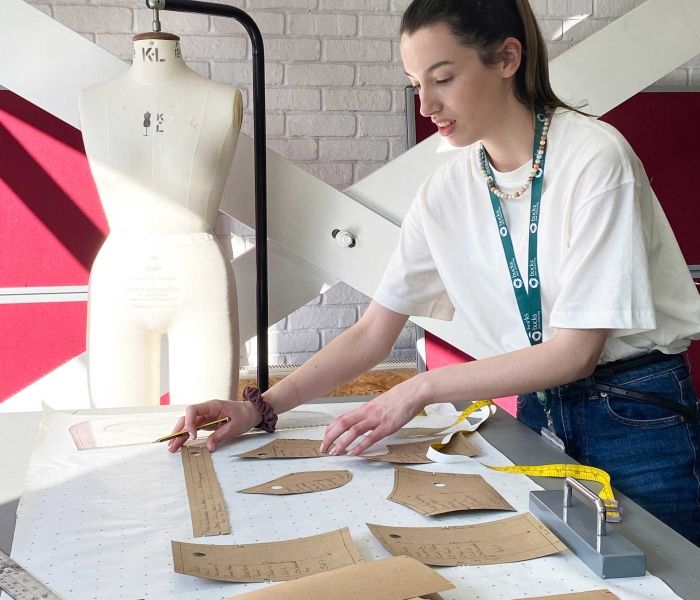 BNU student cutting out fabric for costume
