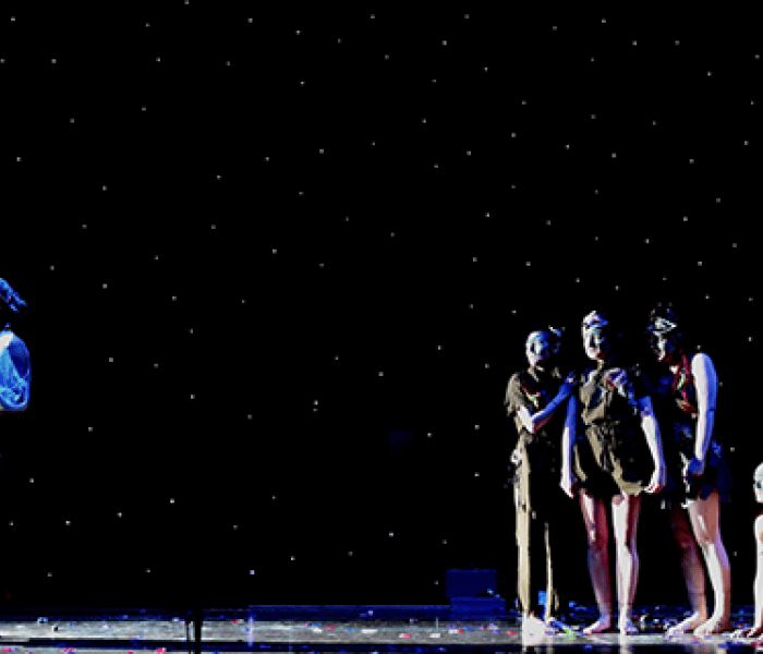 Five performing arts students on stage mid performance