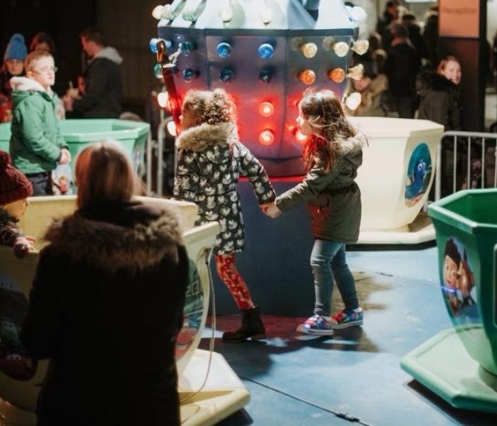 children on teacup rides at event near gateway building