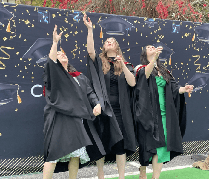 Graduation Class of 2021 students throwing mortar board hats