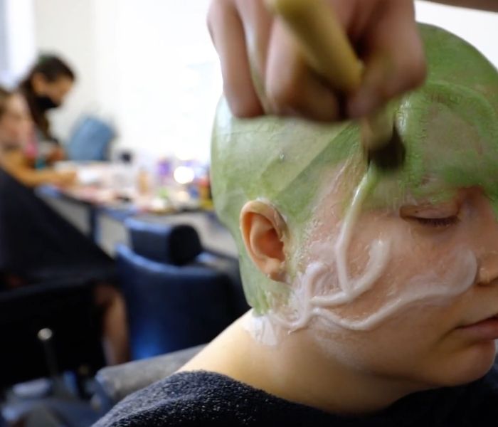 Student wearing green prosthetics on face