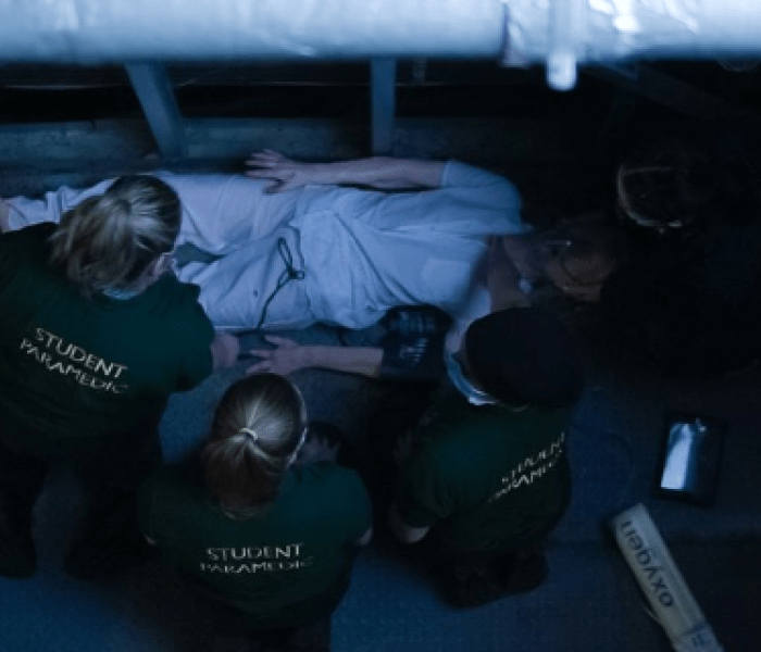 A team of students treat an elderly female (realistic manikin) following a fall