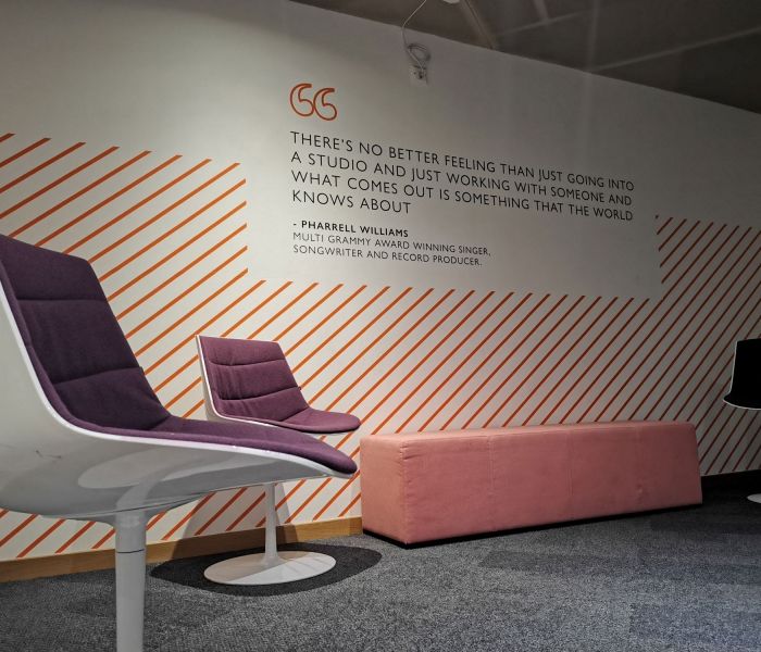 chairs on a stage with quote on wall in the background