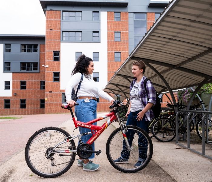 Two  female students talking at the bicycle racks at Hughenden accommodation