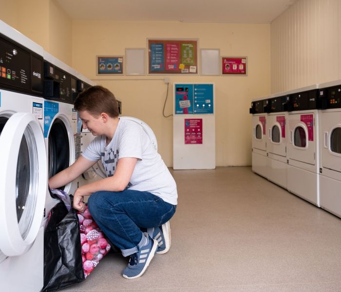 Student washing her clothes at the laundry facilities in Hughenden accommodation