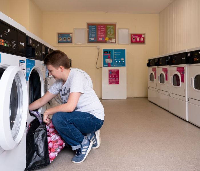 Student washing her clothes at the laundry facilities in Hughenden accommodation