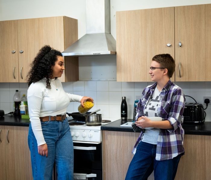 Two students cooking at Hughenden accommodation's shared kitchen