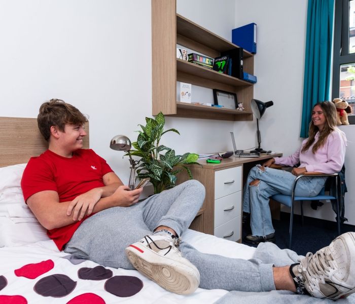 Male and female students talking in a bedroom at Hughenden accommodation