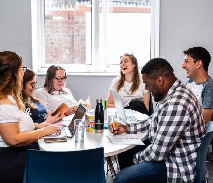 Group of students sitting at the table at Brook Street accommodation in High Wycombe campus
