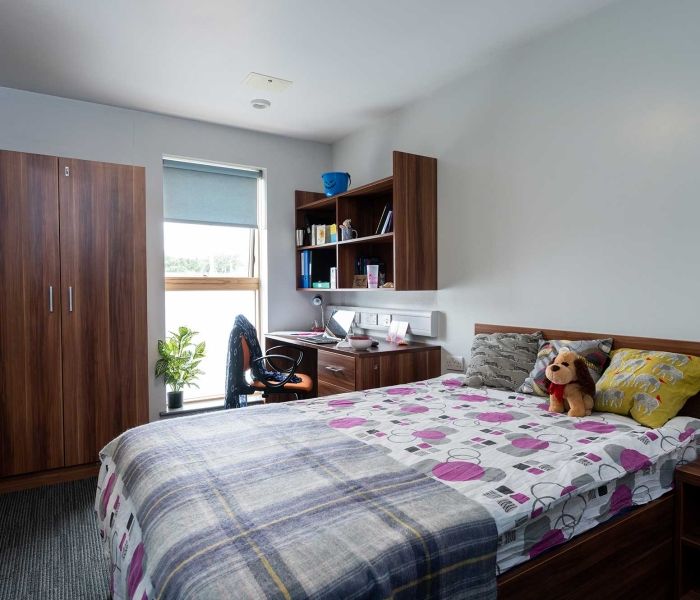 A bed, desk, wardrobe and window in a Windsor House bedroom