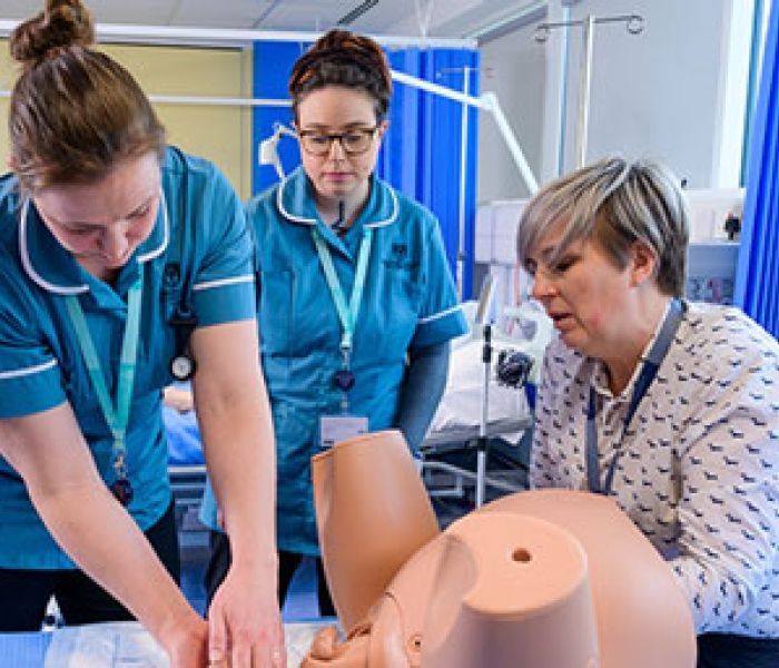 Midwifery students with dummy