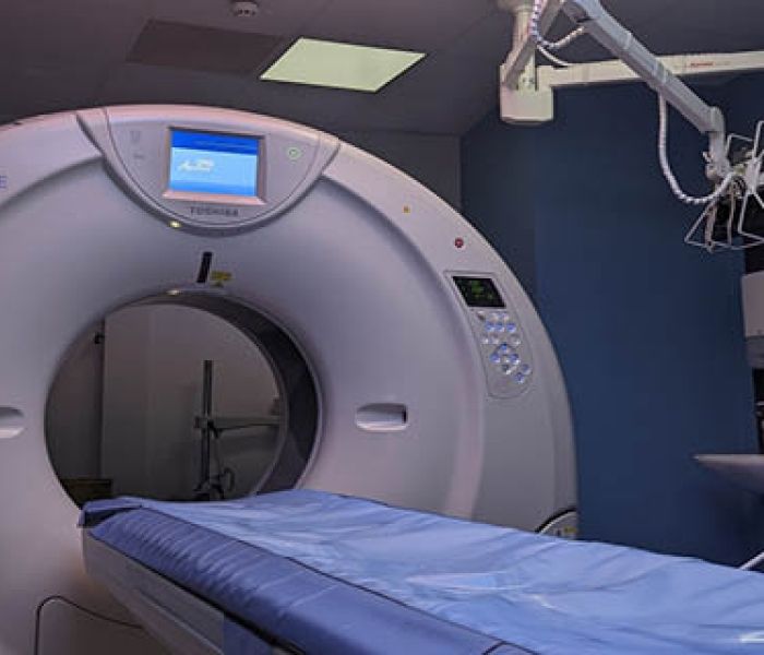 A Diagnostic Radiotherapy machine with a bed next to it in a hospital set up