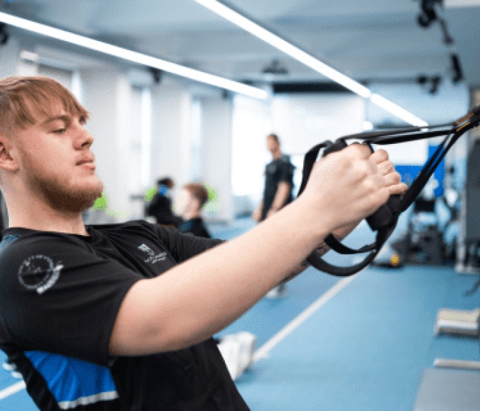 A Sports Therapy student pulling on resistance bands