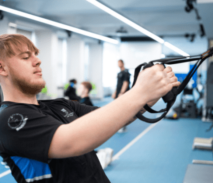 A Sports Therapy student pulling on resistance bands