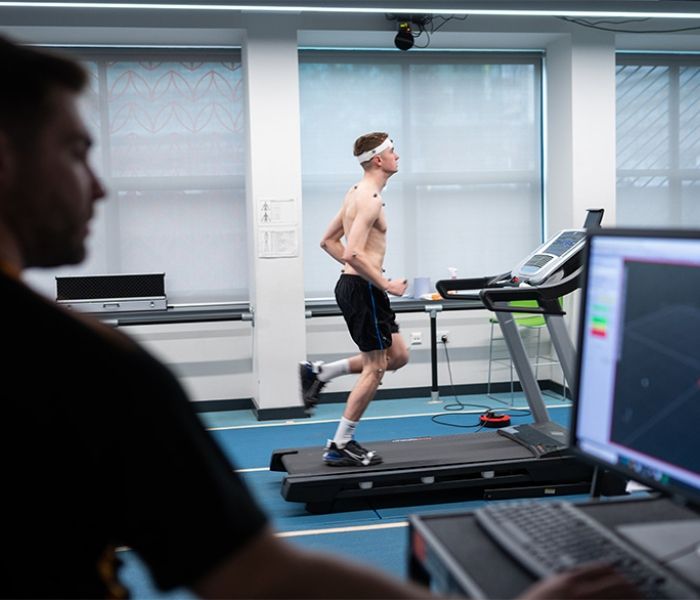 A Sports Therapy student on a treadmill as another student monitors performance on a computer.