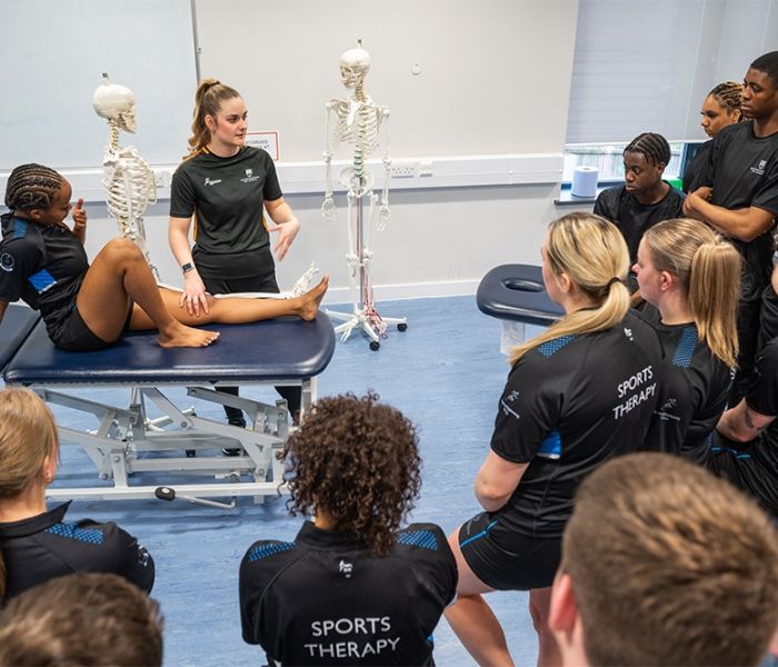 A group of Sports Therapy students watching a demo being given by a fellow student.