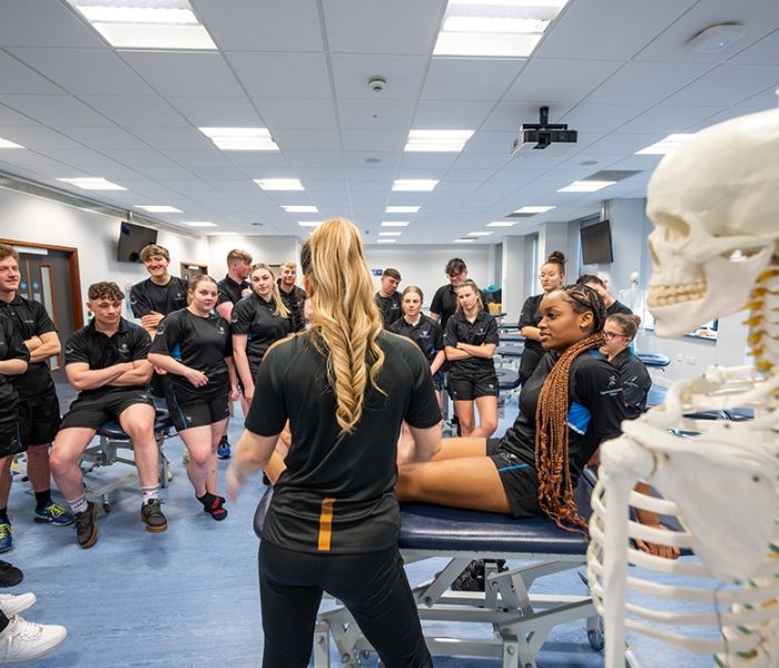 A Sports Therapy student lying down as a demonstration is given to the rest of the class.