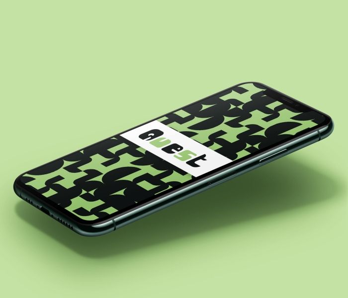 A phone screen slightly elevated which has the word "Quest" written with green and black shapes around it.