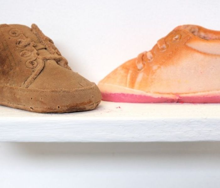 A brown shoe next to a orange shoe.