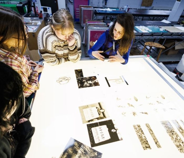 Fine art lecturer discussing with students