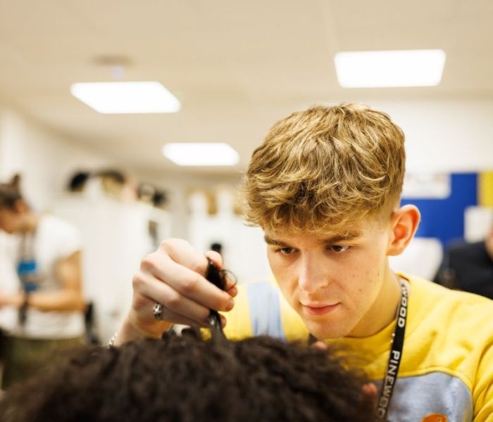 A Hair and Make-up student practicing techniques on a models hair.