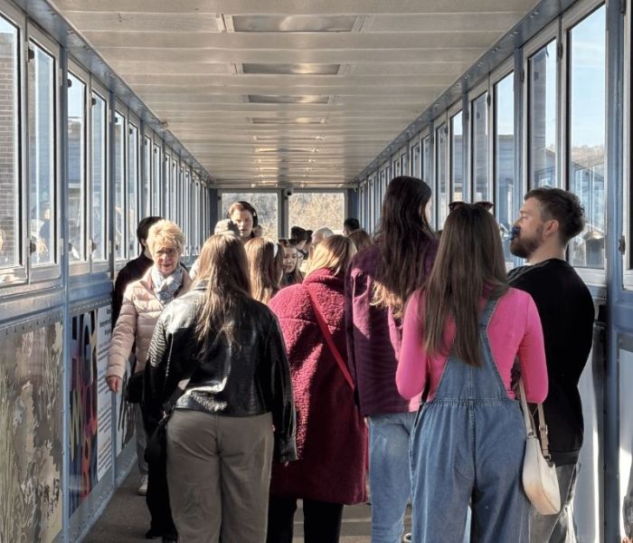 People on a bridge at train station