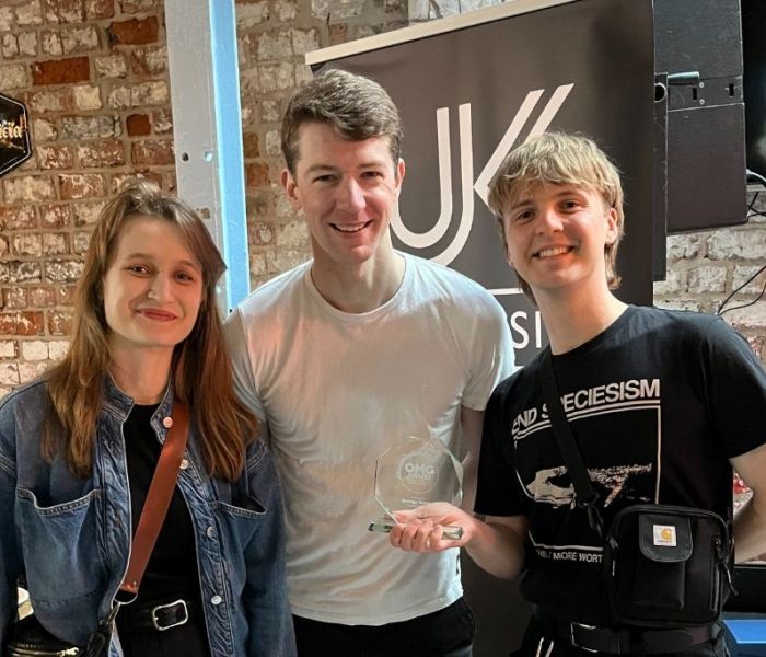 Two students stood either side of a BNU lecturer at the UK Music Awards.