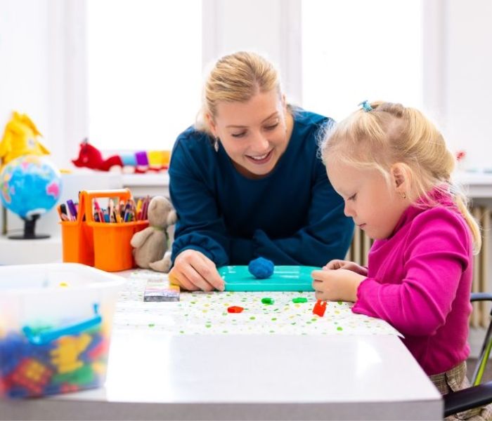 Occupational Therapist supporting a young child through play therapy.