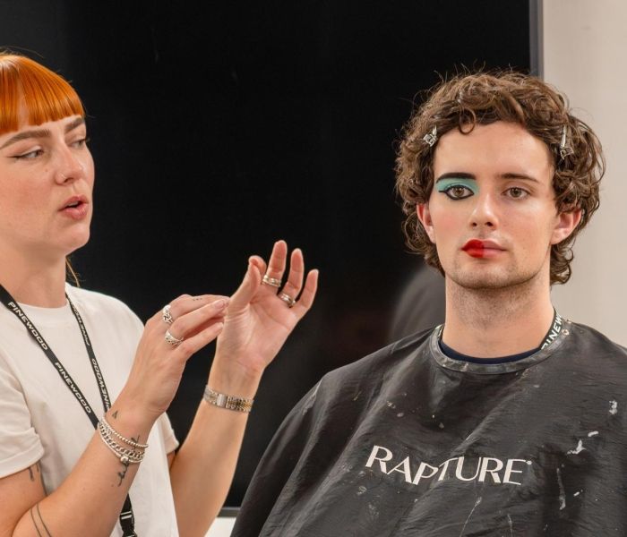A hair and make-up lecturer uses a student to test their SFX skills on.