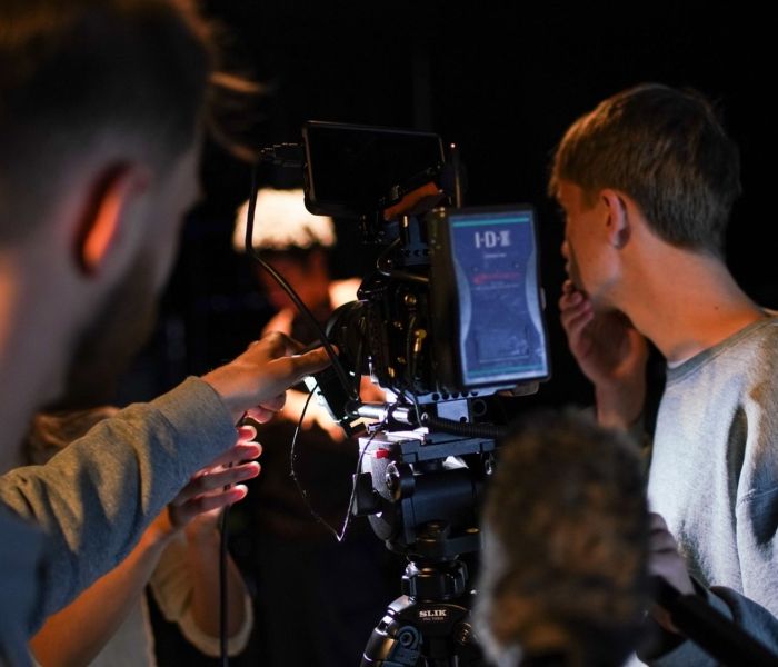 Two students looking through a camera on a tripod