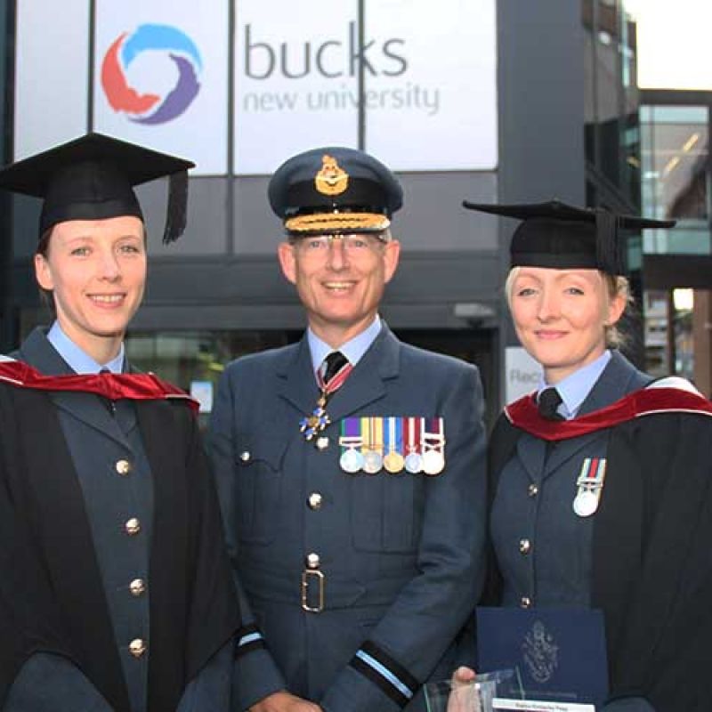 Air Commodore Rich Hill stood in the middle of two female graduates